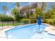 Lovely pool with a blue umbrella surrounded by lush, green landscaping, creating a serene backyard oasis at 4558 E Vista Dr, Phoenix, AZ 85032