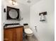 Cozy powder room with decorative mirror, cabinet sink, and toilet at 4558 E Vista Dr, Phoenix, AZ 85032
