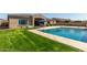 Spacious backyard features large pool, lush lawn, and covered patio perfect for relaxing outdoors at 4884 S Hemet St, Gilbert, AZ 85298