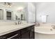 Bathroom featuring double sinks, an oversized tub, dark cabinetry and a large mirror at 4884 S Hemet St, Gilbert, AZ 85298