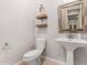 A modern bathroom with a toilet and pedestal sink; decorative shelves add style at 4884 S Hemet St, Gilbert, AZ 85298