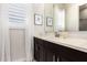 Bathroom featuring a window with sheer curtains, a large mirror, and dark cabinetry at 4884 S Hemet St, Gilbert, AZ 85298