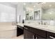 Bathroom featuring double sinks, an oversized tub, dark cabinetry and a large mirror at 4884 S Hemet St, Gilbert, AZ 85298