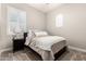 Cozy bedroom featuring a comfortable bed, bedside table with lamp, and bright natural light from the window at 4884 S Hemet St, Gilbert, AZ 85298