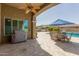 Inviting covered patio, ceiling fan, travertine pavers, outdoor grill, and view of private pool at 4884 S Hemet St, Gilbert, AZ 85298
