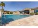 Sparkling pool with tiled surround and rock waterfall feature, set against blue sky at 4884 S Hemet St, Gilbert, AZ 85298