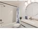 Clean bathroom with a tub/shower, white subway tile, and round mirror at 5142 E Holly St, Phoenix, AZ 85008