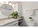 Bright bathroom featuring a round mirror, gray countertop, and white cabinets at 5142 E Holly St, Phoenix, AZ 85008