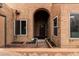 Inviting arched entrance featuring a Ring doorbell, decorative planters, and iron security gate at 5142 E Holly St, Phoenix, AZ 85008