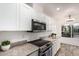 Close up of updated kitchen with stainless appliances, granite counters, and tile flooring at 5142 E Holly St, Phoenix, AZ 85008