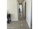 Long hallway featuring tile floors and white doors, leading to various rooms of the house at 6107 N 126Th Ave, Litchfield Park, AZ 85340