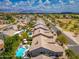 Magnificent aerial view of charming neighborhood with sparkling pools, lush landscaping, tiled roofs, and mountain views at 6438 E Montreal Pl, Scottsdale, AZ 85254