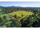 Scenic aerial view of the golf course, with vast green fields, trees, and distant mountains at 6438 E Montreal Pl, Scottsdale, AZ 85254