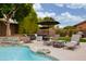 Outdoor space with pool, waterfall feature, lounge chairs, and manicured landscaping at 6438 E Montreal Pl, Scottsdale, AZ 85254
