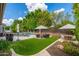 Backyard featuring a pool, outdoor kitchen, a lush lawn, and comfortable lounge areas for relaxation at 6438 E Montreal Pl, Scottsdale, AZ 85254