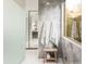 A stylish bathroom with large grey tiles, a rain shower, frosted glass, and a wooden stool near a well lit window at 6438 E Montreal Pl, Scottsdale, AZ 85254