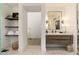 Well-lit bathroom with floating vanity, modern finishes, and open shelving for storage at 6438 E Montreal Pl, Scottsdale, AZ 85254