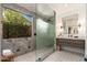 Modern bathroom featuring stone-look tile, glass shower, and a floating vanity at 6438 E Montreal Pl, Scottsdale, AZ 85254