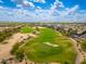 Expansive aerial shot of a golf course with meticulously maintained greens, bunkers, and surrounding neighborhood at 6438 E Montreal Pl, Scottsdale, AZ 85254