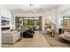 Bright living room with a fireplace, comfortable seating, and views of the outdoor pool area at 6438 E Montreal Pl, Scottsdale, AZ 85254
