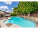 Private backyard pool with a stone waterfall feature and lush landscaping at 6438 E Montreal Pl, Scottsdale, AZ 85254