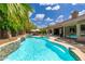 Inviting pool area with stone waterfall feature, surrounded by lush landscaping and comfortable lounge seating at 6438 E Montreal Pl, Scottsdale, AZ 85254