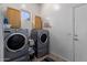 Laundry room with two front-load washer and dryer units and wooden cabinets at 7150 W Avenida Del Rey --, Peoria, AZ 85383