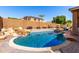 Backyard pool with a rock waterfall feature, a brick coping, and outdoor seating at 7150 W Avenida Del Rey --, Peoria, AZ 85383