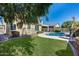 This backyard offers a pool, lush lawn, and patio, creating an inviting outdoor space for relaxation and entertainment at 7363 E Plata Ave, Mesa, AZ 85212