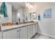 Bright bathroom features dual sinks, stone countertops, white cabinets and brushed hardware at 7363 E Plata Ave, Mesa, AZ 85212