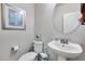 Cozy powder room featuring neutral paint, white fixtures, framed artwork, and a pedestal sink at 7363 E Plata Ave, Mesa, AZ 85212