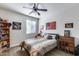 Bedroom featuring a ceiling fan, window with blinds, a full bed, and American flag wall art at 7363 E Plata Ave, Mesa, AZ 85212