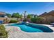 Private pool and spa combination with natural stone features and lush landscaping at 7363 E Plata Ave, Mesa, AZ 85212