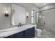 Modern bathroom featuring a sleek vanity, glass-enclosed shower, and gray tiled walls at 8040 E Carol Way, Scottsdale, AZ 85260