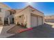 Two-car garage with colorful landscaping, red trim, and stucco exterior at 835 N Granite Reef Rd # 29, Scottsdale, AZ 85257