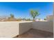 Outdoor patio area with textured walls and views of trees and nearby buildings at 835 N Granite Reef Rd # 29, Scottsdale, AZ 85257