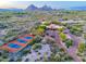Expansive aerial view of desert estate featuring multiple buildings and a red-and-green tennis court at 9716 E Mariposa Grande Dr, Scottsdale, AZ 85255