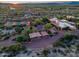Aerial view shows the property including a tennis court, covered parking and tile roof at 9716 E Mariposa Grande Dr, Scottsdale, AZ 85255
