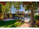Lush backyard with a pool, outdoor seating, and mature trees, creating a private and serene retreat at 9716 E Mariposa Grande Dr, Scottsdale, AZ 85255