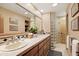Bathroom featuring dual sinks, glass block accents, and a large mirror at 9716 E Mariposa Grande Dr, Scottsdale, AZ 85255