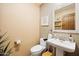 Powder bathroom with a pedestal sink, wood accents, neutral tones, and stylish design at 9716 E Mariposa Grande Dr, Scottsdale, AZ 85255