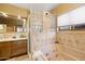 Bathroom featuring a large soaking tub with glass block accents, a vanity, and a window for natural light at 9716 E Mariposa Grande Dr, Scottsdale, AZ 85255