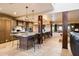 Large kitchen island with bar seating, custom cabinets, stone counters, and rustic wood accents at 9716 E Mariposa Grande Dr, Scottsdale, AZ 85255