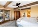 Spacious bedroom featuring exposed wood beams, a ceiling fan, and outdoor access to a private patio at 9716 E Mariposa Grande Dr, Scottsdale, AZ 85255