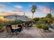 Inviting patio area with tables, chairs, umbrellas, and lush landscaping perfect for outdoor relaxation and entertaining at 9716 E Mariposa Grande Dr, Scottsdale, AZ 85255