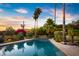 Stunning pool area with palm trees, colorful plants, and a waterfall feature creating a tranquil oasis at 9716 E Mariposa Grande Dr, Scottsdale, AZ 85255