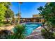 Inviting pool area surrounded by mature landscaping and an outdoor kitchen, perfect for relaxation and entertaining at 9716 E Mariposa Grande Dr, Scottsdale, AZ 85255