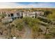 Expansive aerial view of an estate home with a clay tile roof, lush greenery, and a private driveway in a beautiful neighborhood at 10244 E Hualapai Dr, Scottsdale, AZ 85255