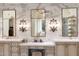 Luxurious bathroom featuring marble walls, dual vanities, and stylish lighting fixtures at 10244 E Hualapai Dr, Scottsdale, AZ 85255