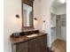 Bathroom features a dark wood vanity, sconces, dark bronze fixtures, and a walk in closet at 10244 E Hualapai Dr, Scottsdale, AZ 85255